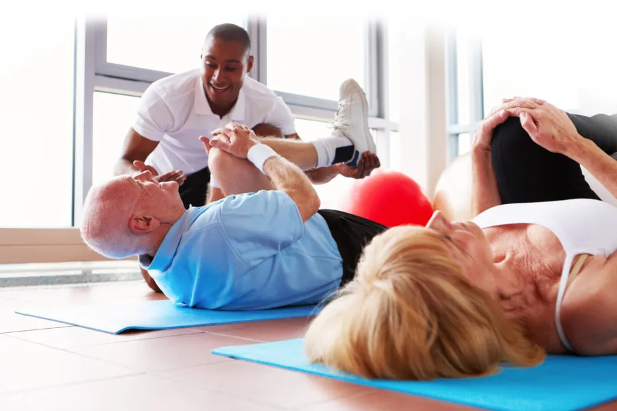 Therapist guiding patients through corrective stretching and physical therapy exercises